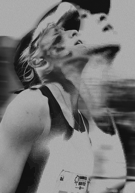 Black and white artistic double exposure of a smiling runner wearing a cap and race bib looking upwards.