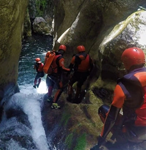 Excited group conquering Nevidio canyon on guided canyoning tour, Bosnia and Herzegovina