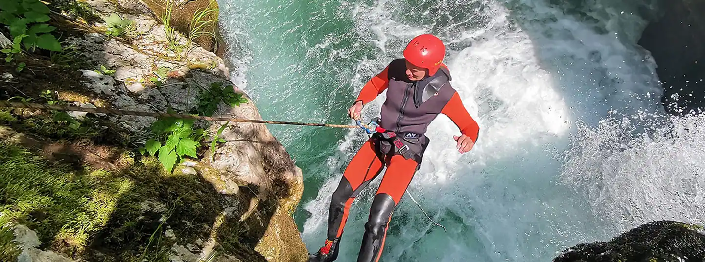 Guest jumping into natural turquoise pool during Hrčavka canyoning tour, Sutjeska National Park