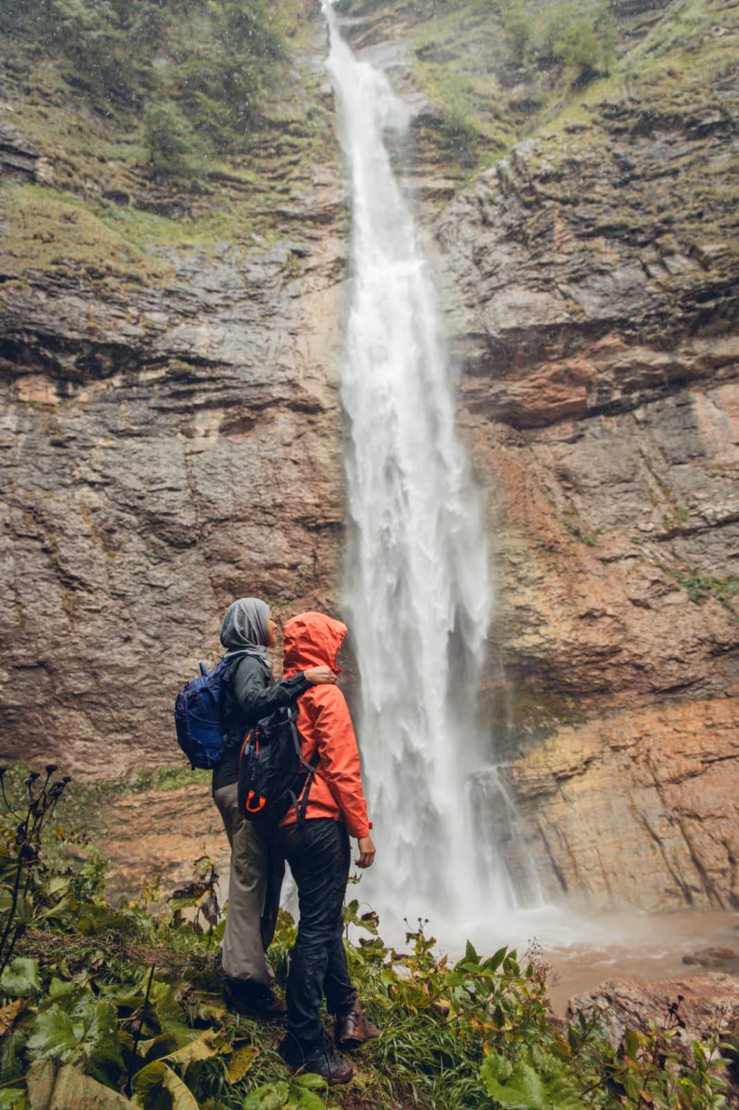 Two hikers at Skakavac Waterfall in Perućica forest, guided hiking tour Sutjeska National Park Bosnia Herzegovina