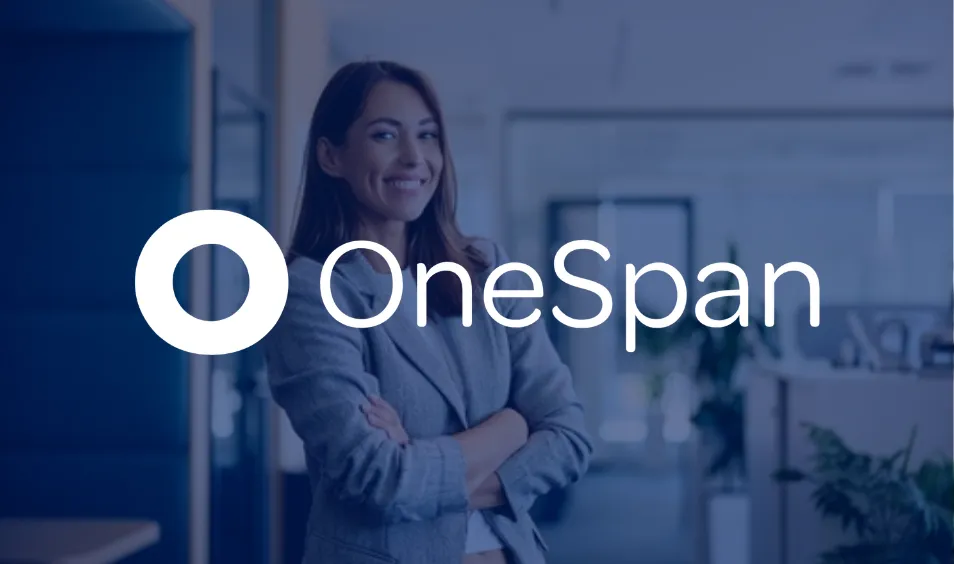 Smiling woman in a blazer stands with arms crossed in a modern office behind OneSpan logo.