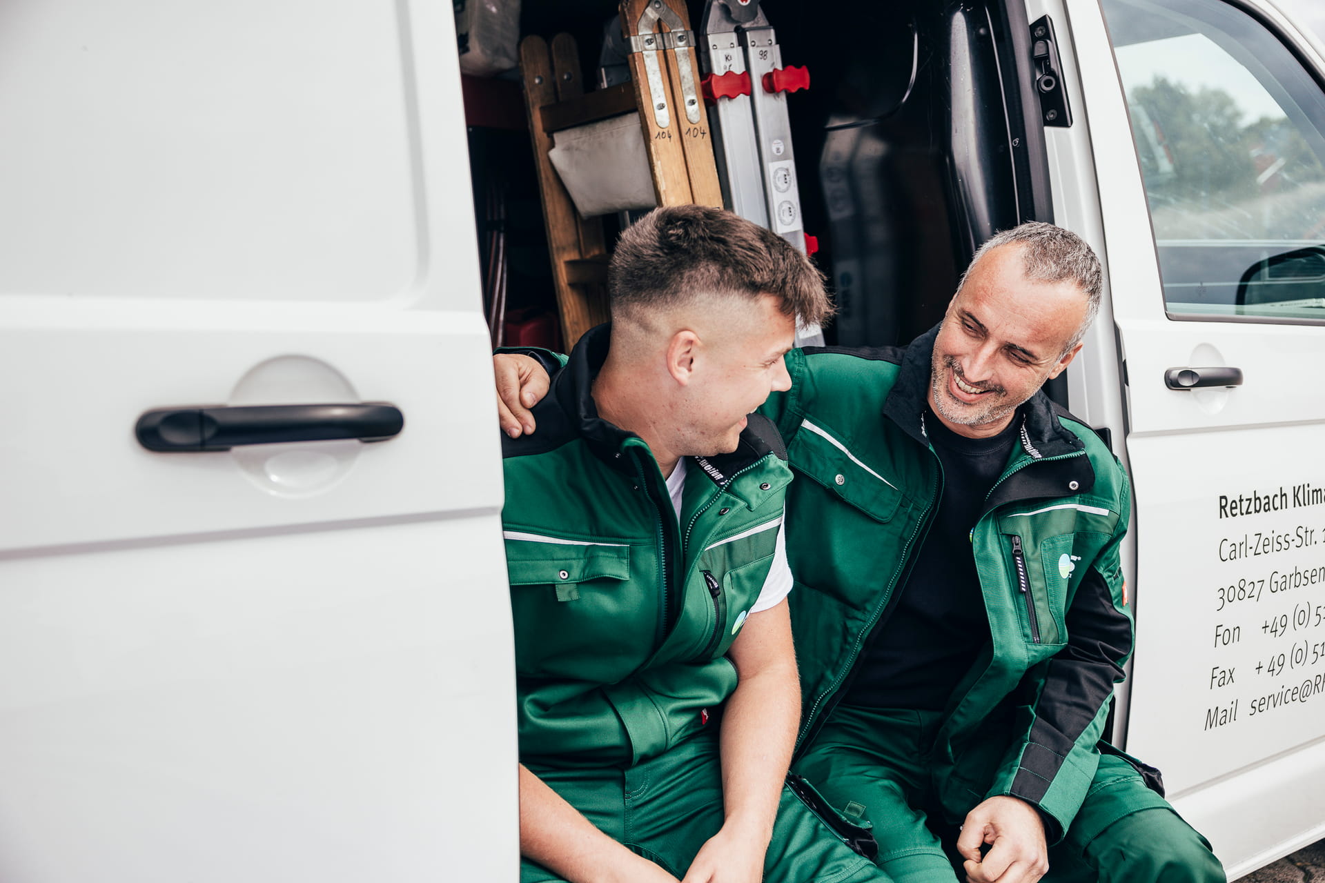 Zwei Mitarbeiter sitzen gemeinsam in ihrem Werkzeugtransporter