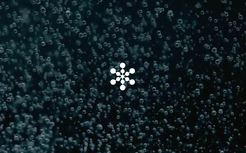Close-up of numerous small bubbles rising in dark water, with a white molecular structure symbol centered.