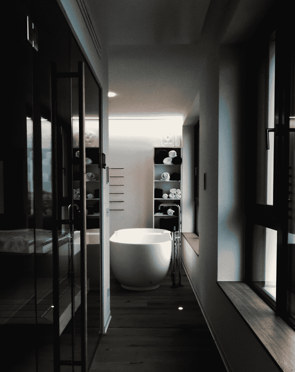 White sports car driving fast on a snowy mountain road with snow-covered hills and a partly cloudy sky.