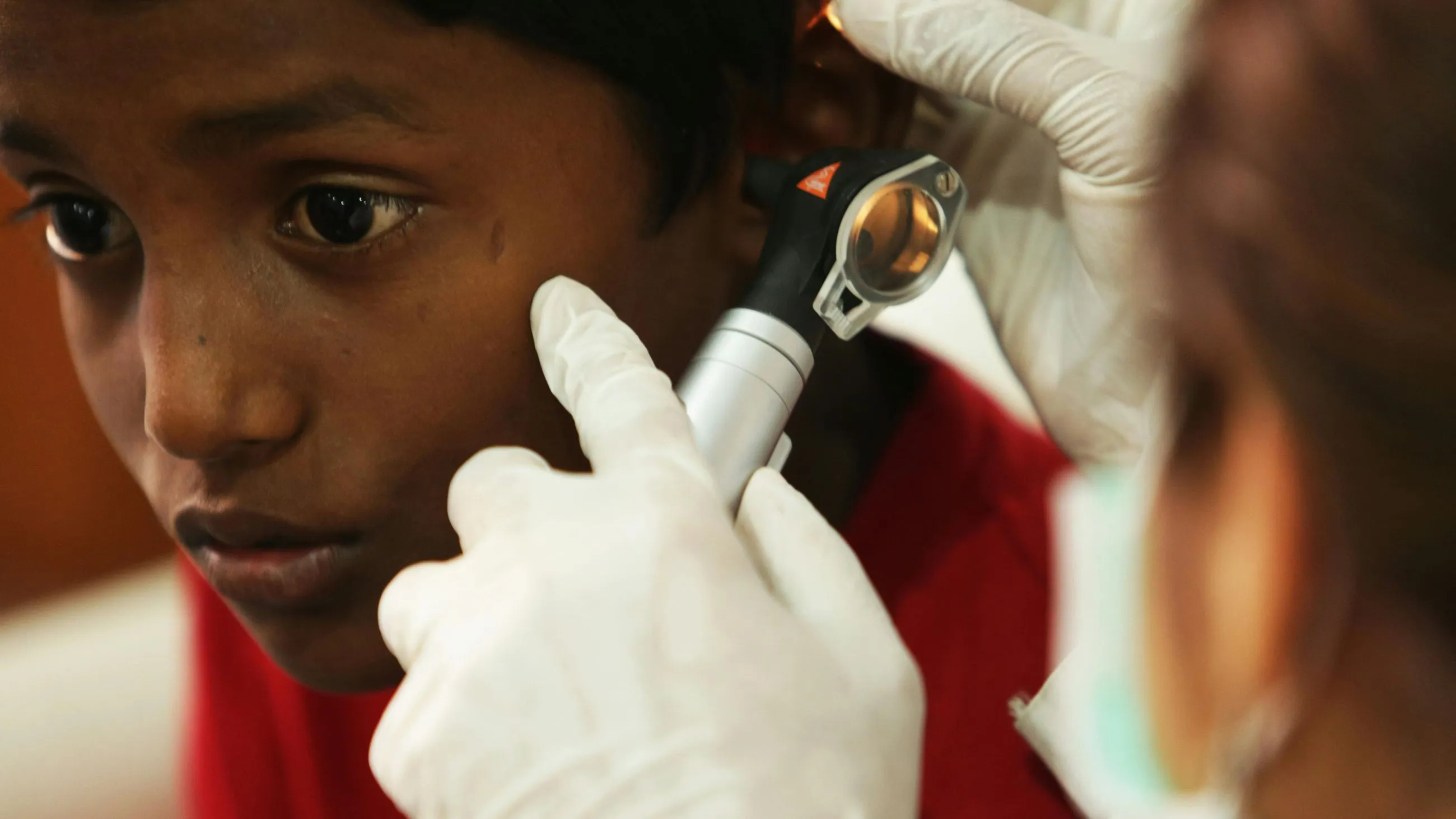 Doctor examining patient's eye with medical otoscope during checkup