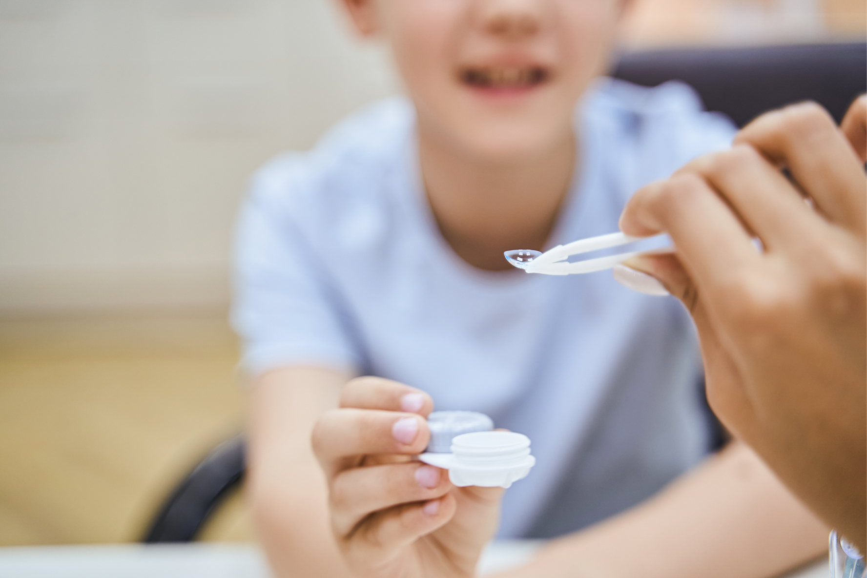 Ophthalmologist showing contact lenses to a child patient