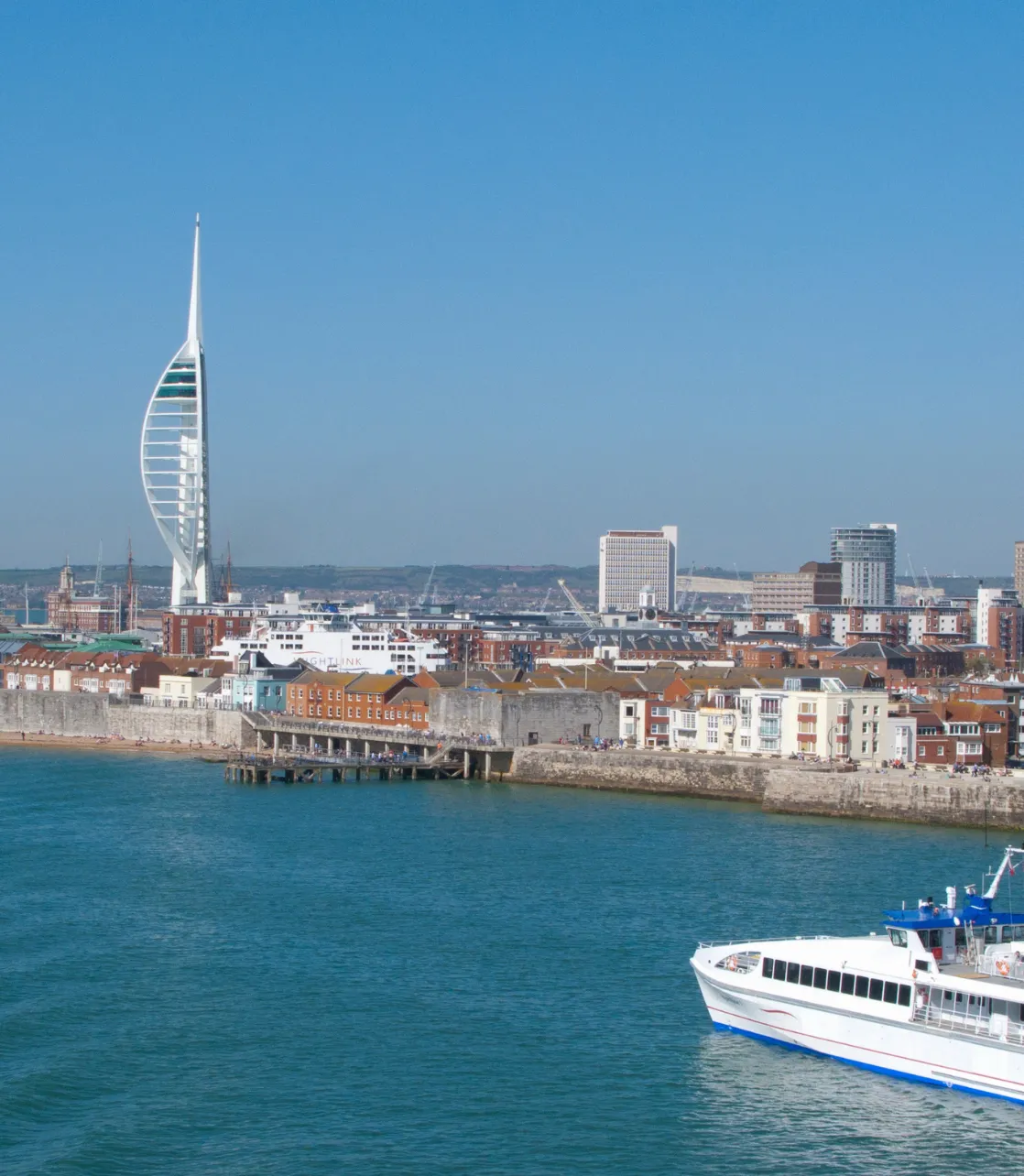 Image of Portsmouth harbour, featuring the Spinnaker Tower and a Wighlink ferry crossing the water.