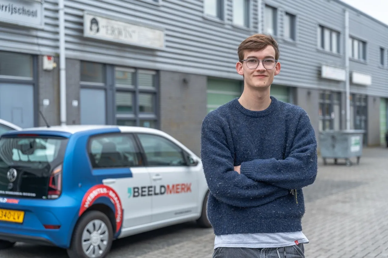 Gunnar van der Stoel, oprichter van Beeldmerk, voor de bestickerde Beeldmerk-bedrijfsauto in Kampen