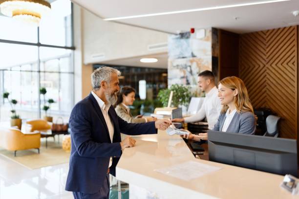 Photo depicting a guest interacting with staff at a hotel front desk