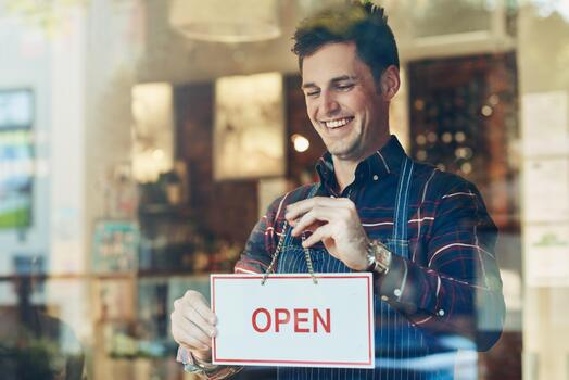 A store owner turns their sign from closed to open
