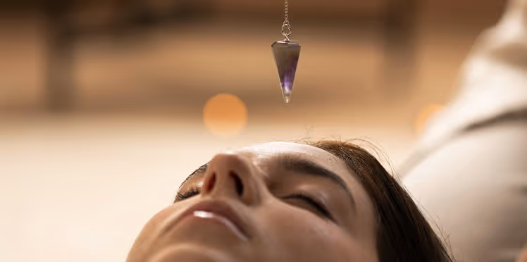Woman with a necklace dangling above her face