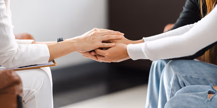 Two peoples' hands holding each other