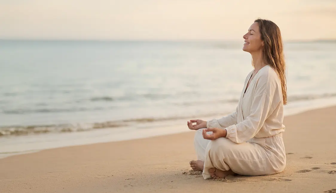 A woman meditates on peacefully on the beach