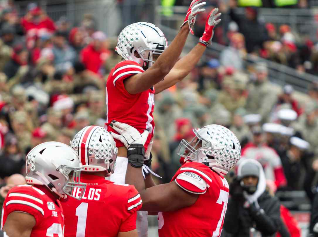 Ohio football players at the stadium with crowd watching