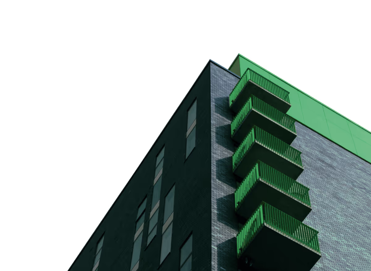 Low-angle view of a modern building corner with green balconies and windows.