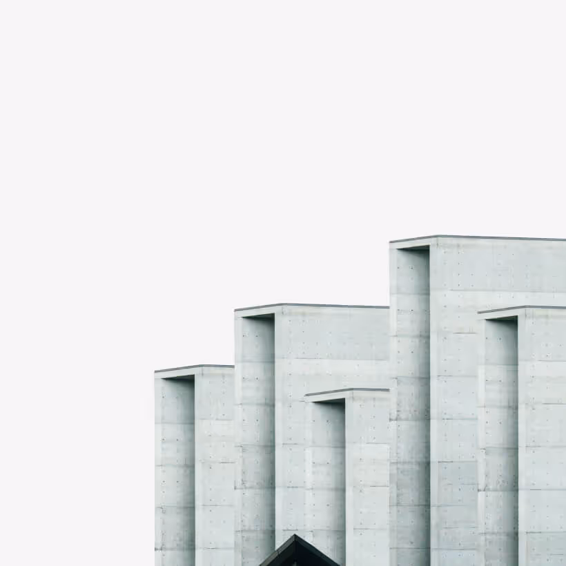 Minimalist concrete building with multiple rectangular vertical sections against a plain sky.