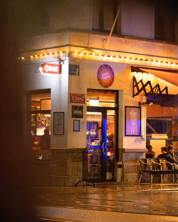 Buitenaanzicht van het café met verlichte gevel .