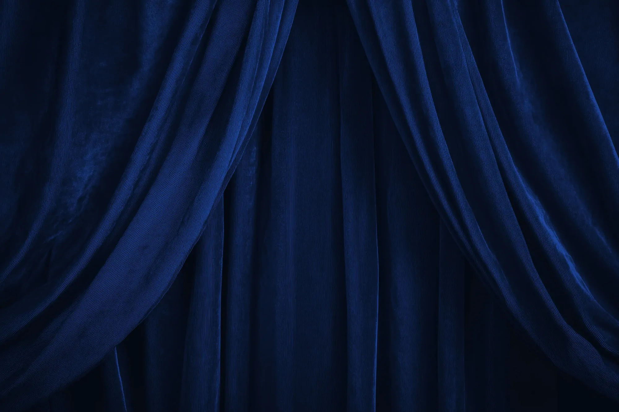 Dark blue velvet curtains with soft folds and draping fabric.