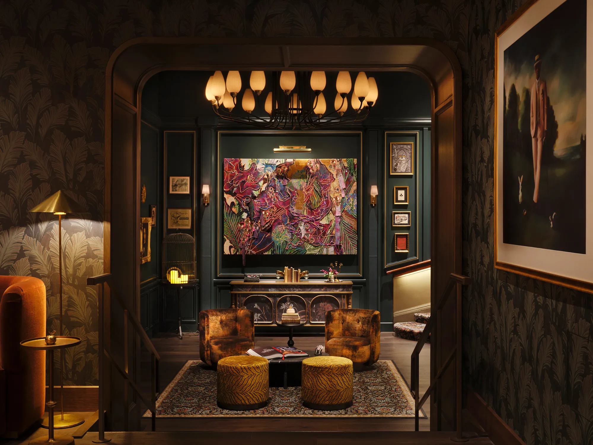 Cozy living room with dark walls, patterned carpet, modern art, and warm ambient lighting.