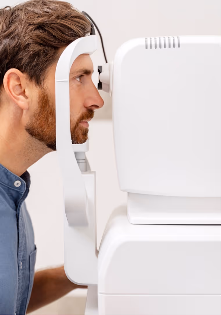 Man looking into an eye examination device during an eye test.