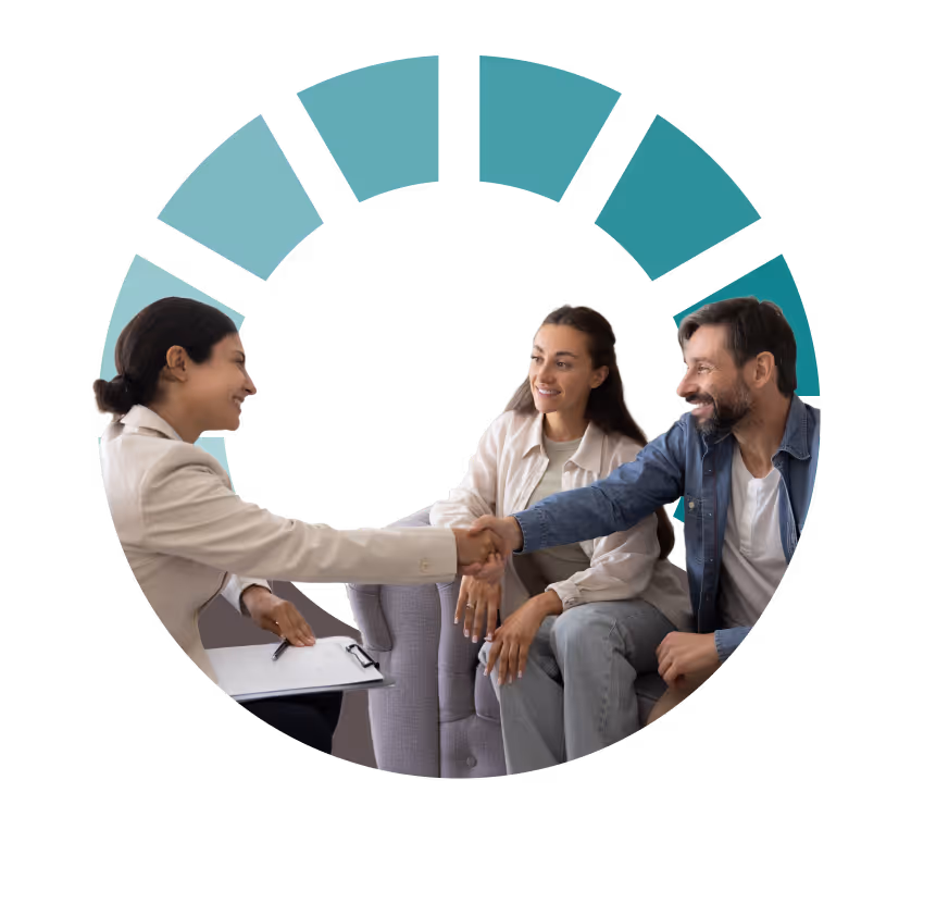 A professional woman shaking hands with a smiling mother and father on a couch, representing Individualized Education Program (IEP) consulting and advocacy support.