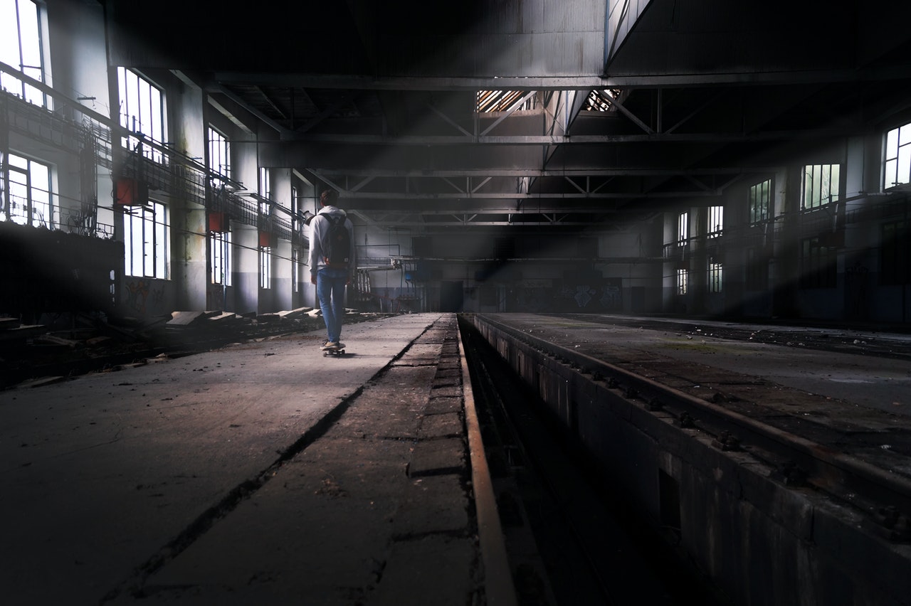 A man standing on the floor of an abandoned factory