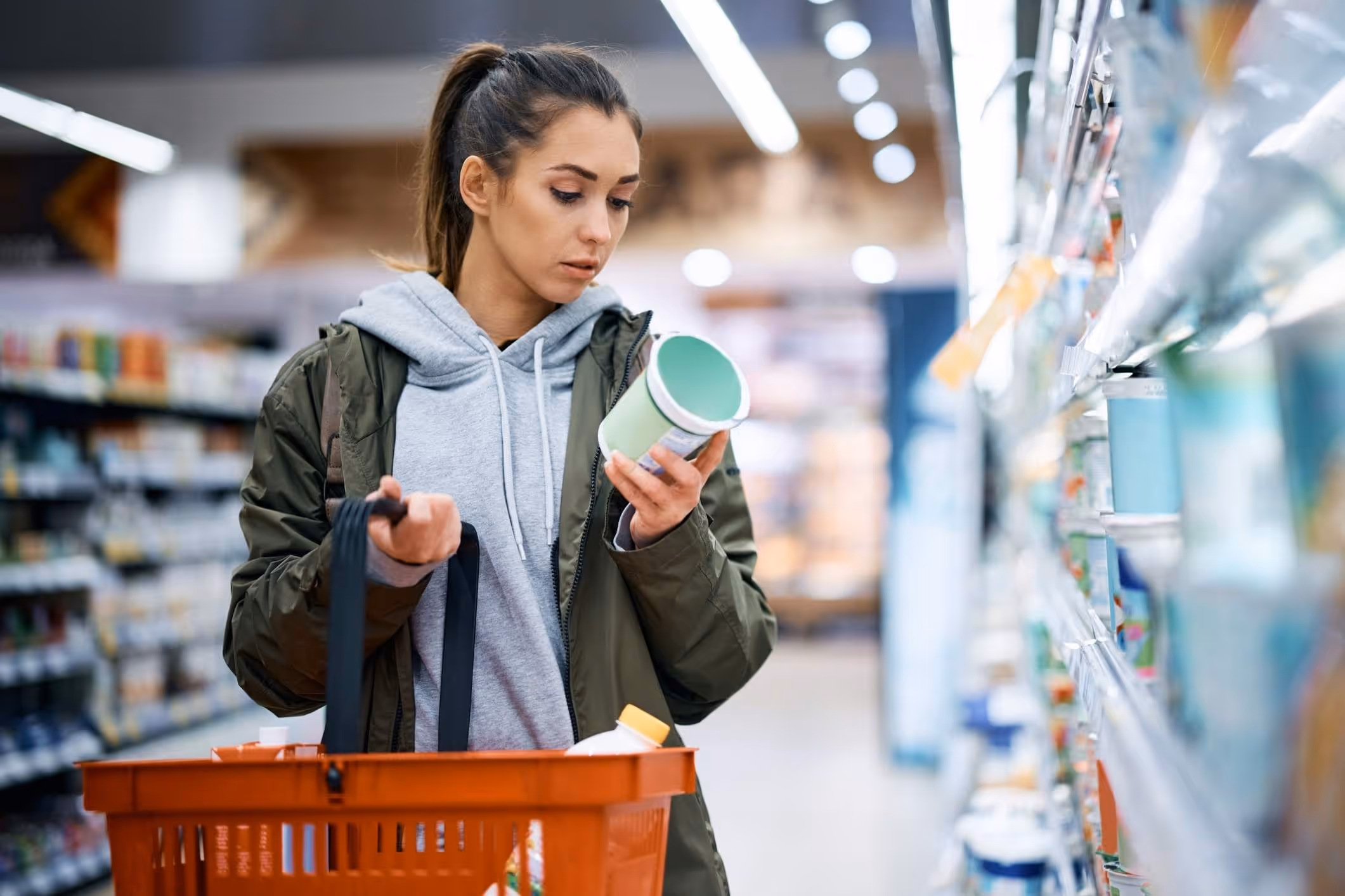 A woman reads a misleading nutrition label as she considers pursuing a false advertising lawsuit.