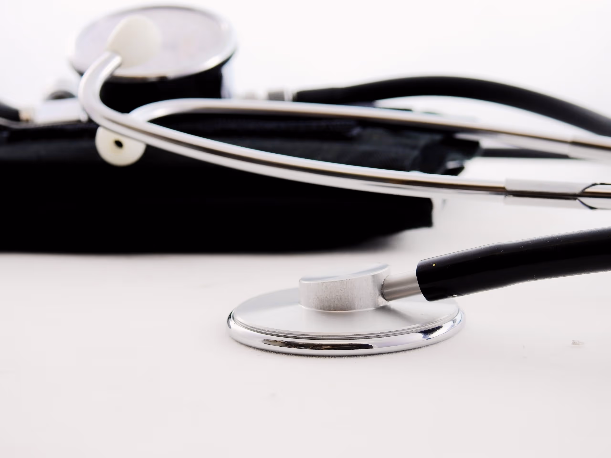 A stethoscope and blood pressure cuff on a white table