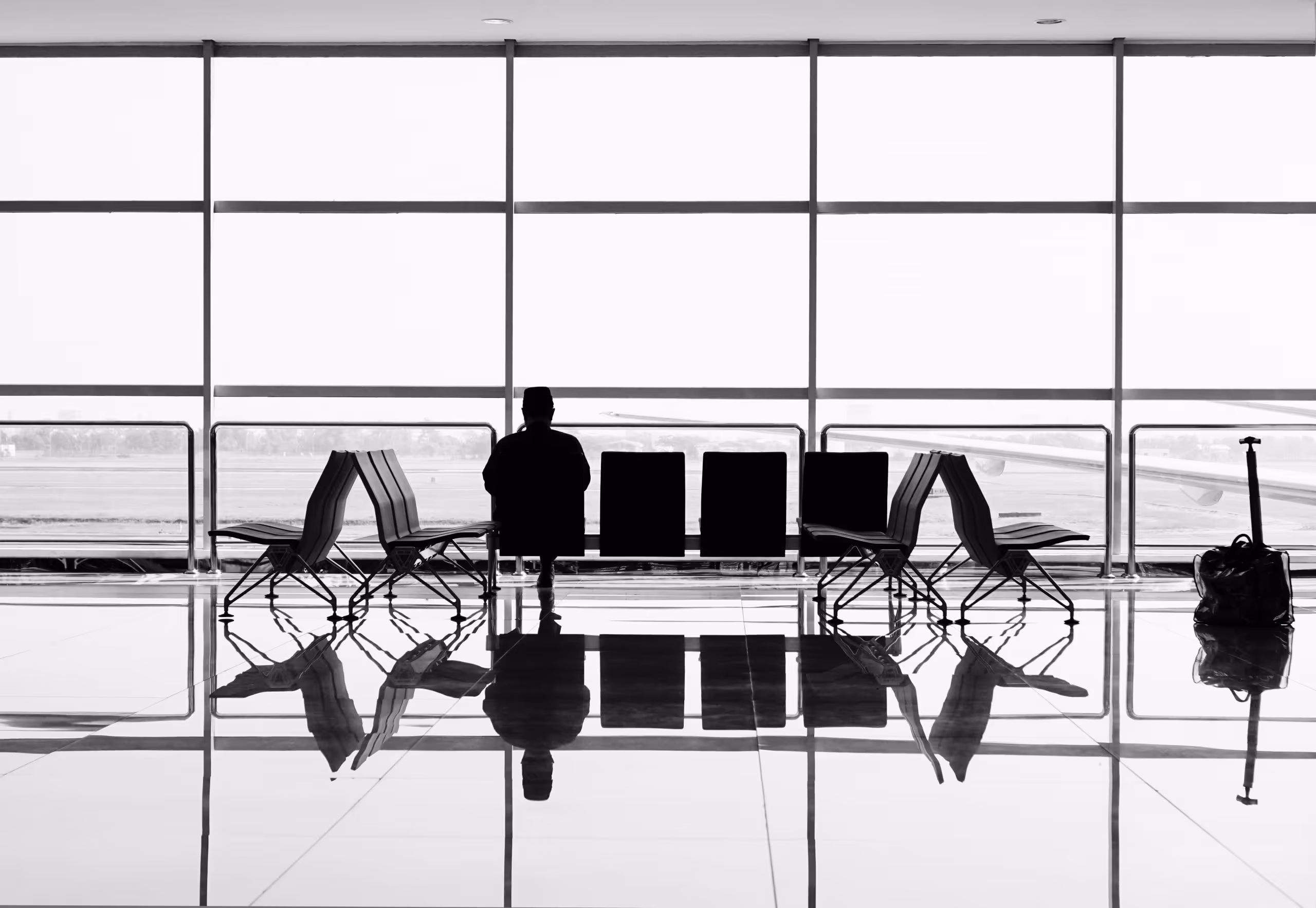 A person sitting in a seat at an airport terminal