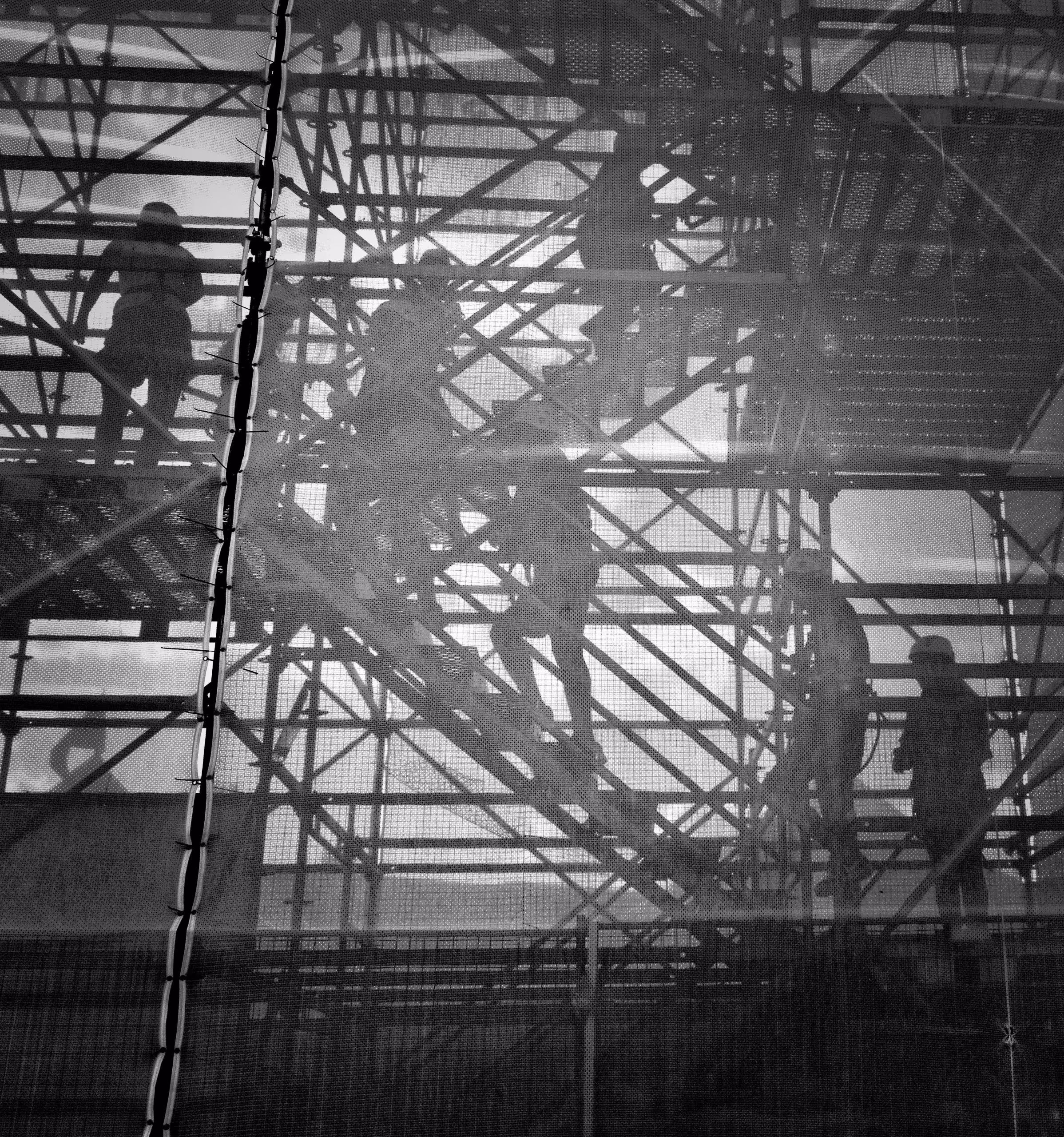 workers climb construction scaffolding
