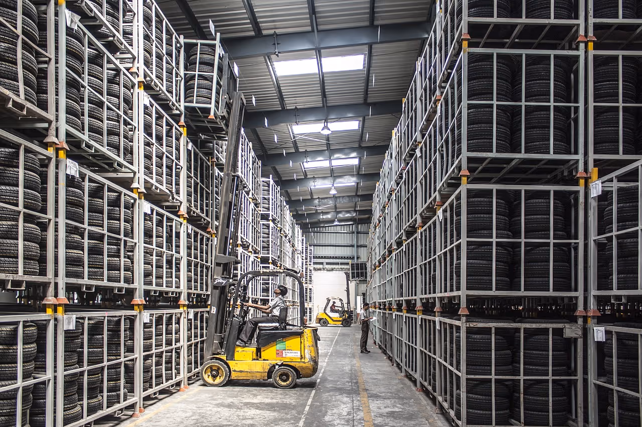 A man operating forklift in tire warehouse