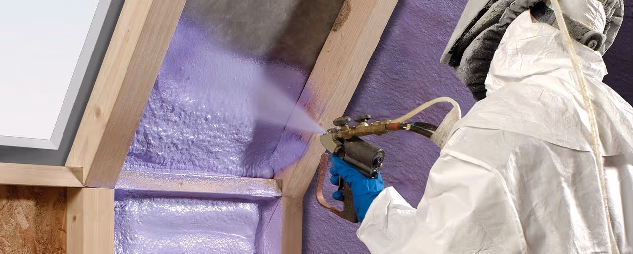 a worker in a hazmat suit spraying chemicals