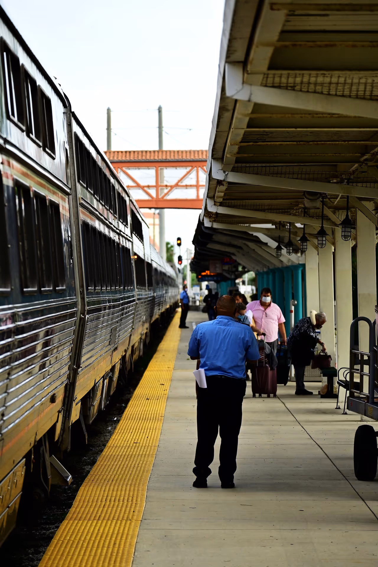 Amtrak worker on platform with train arriving