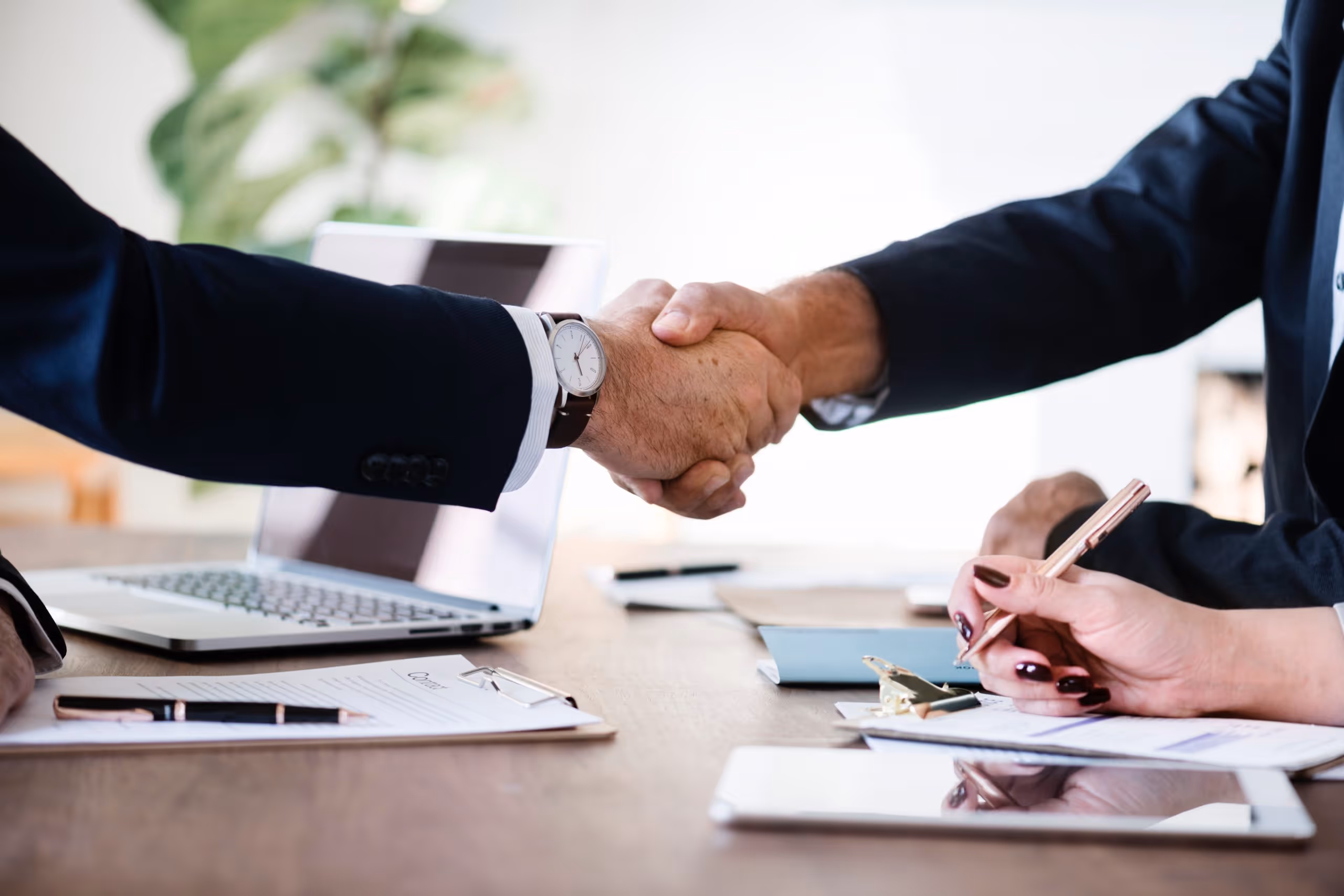 two men shaking hands over a conference table