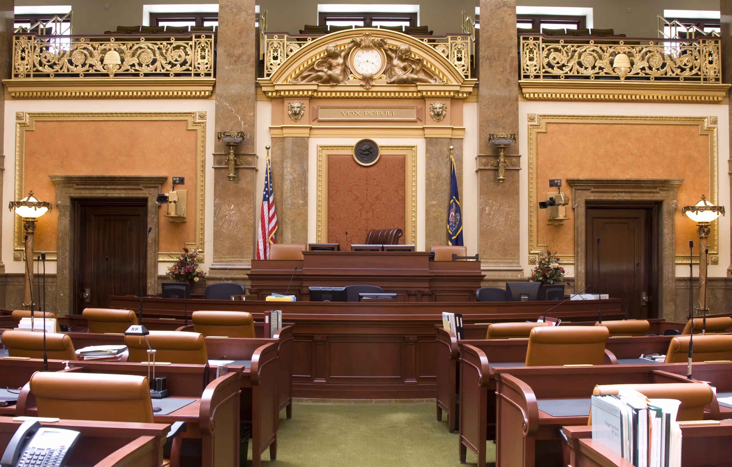 An empty courtroom with flags displayed in front