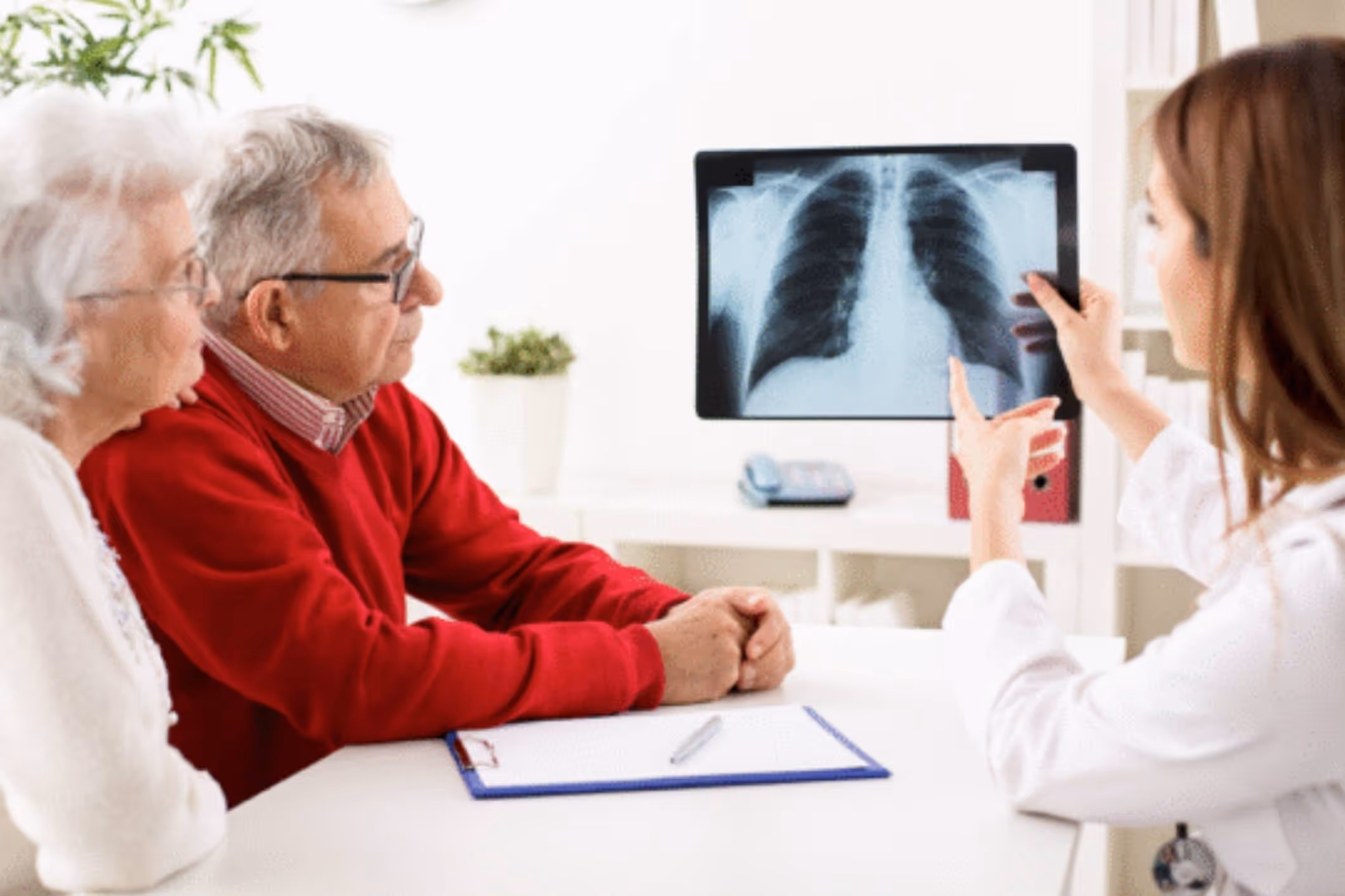 Senior couple examining chest scan, highlighting why mesothelioma patients need asbestos lawsuit lawyers.