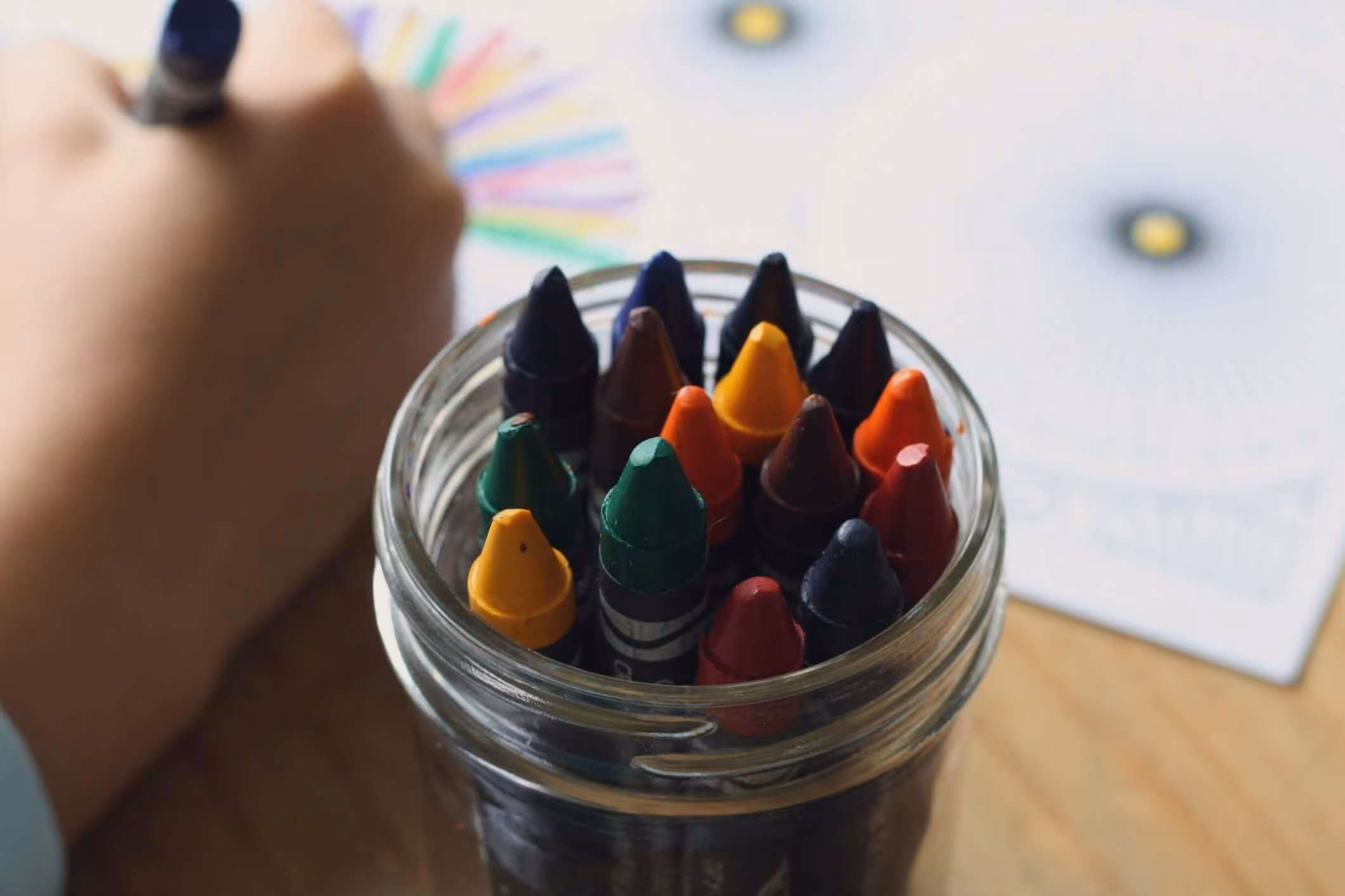 A child plays with school supplies like crayons and construction paper