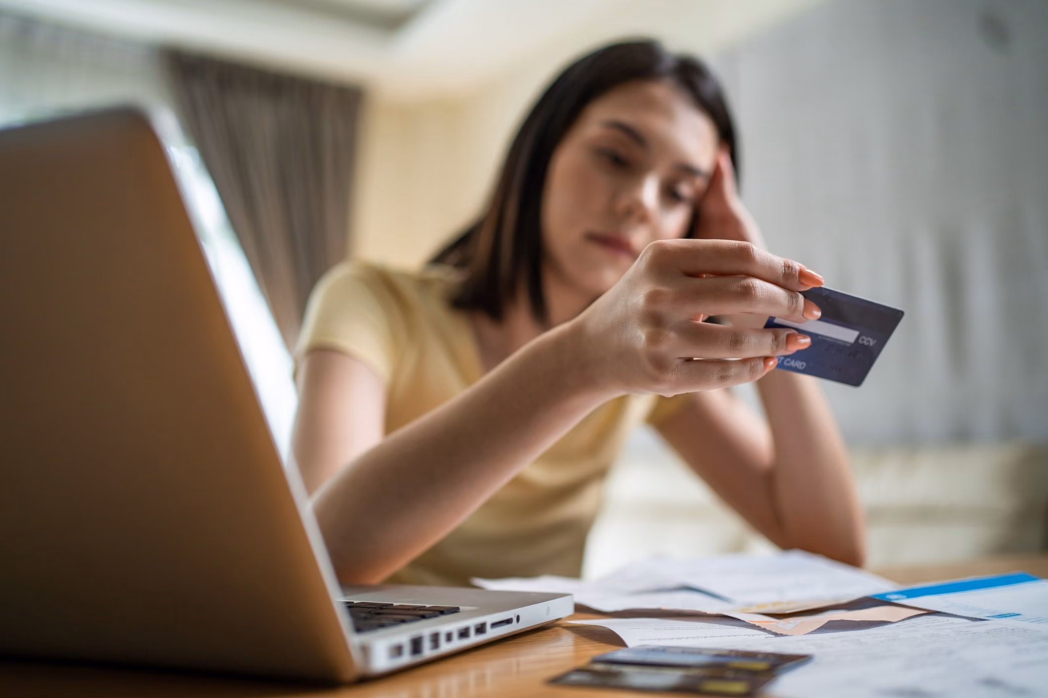 A woman reviewing her credit card statements, wondering if she should contact a consumer fraud lawyer.