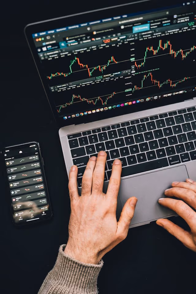 A man on his computer and phone making trades