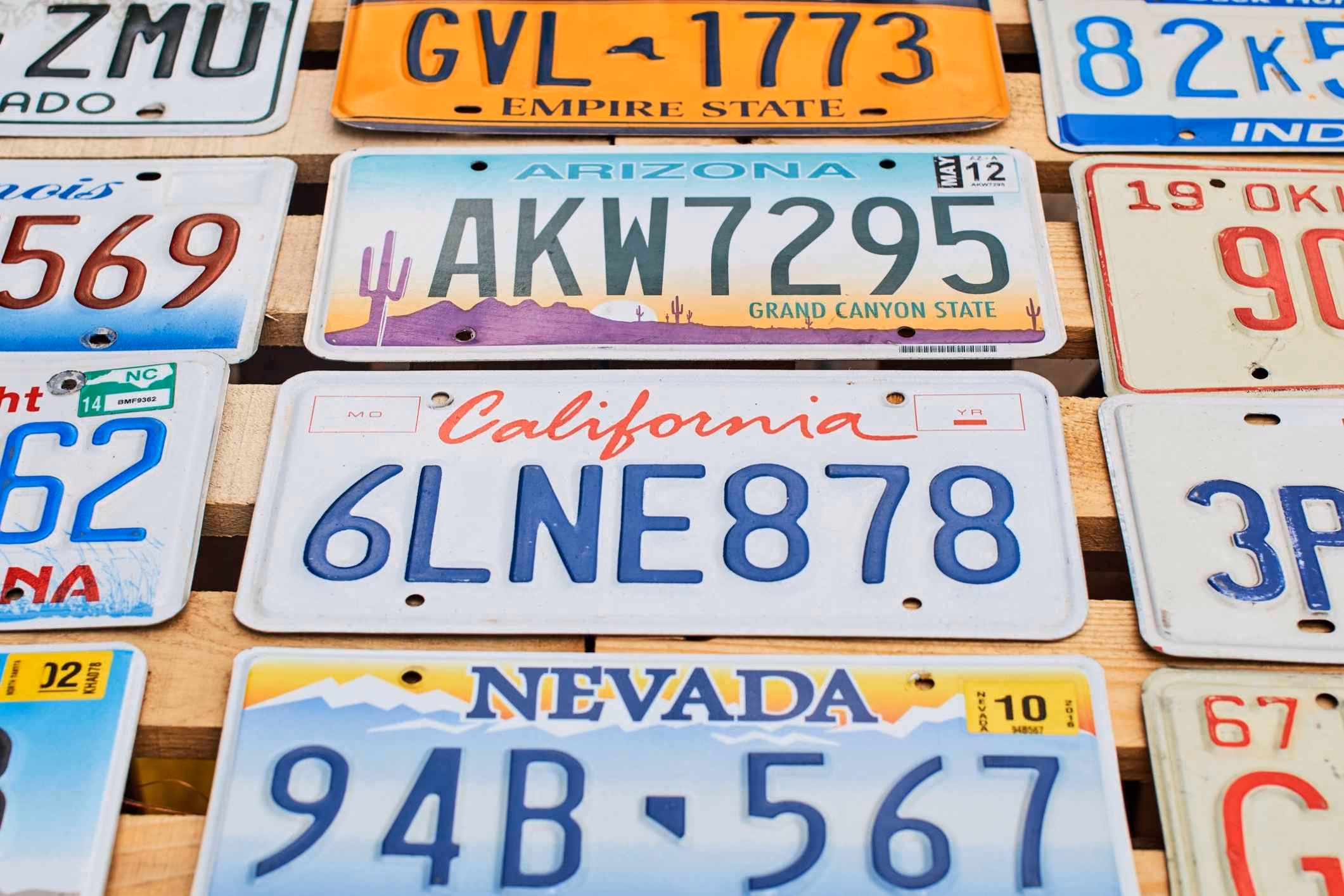 Vehicle license plates mounted on a wall, representing a license plate reader lawsuit.