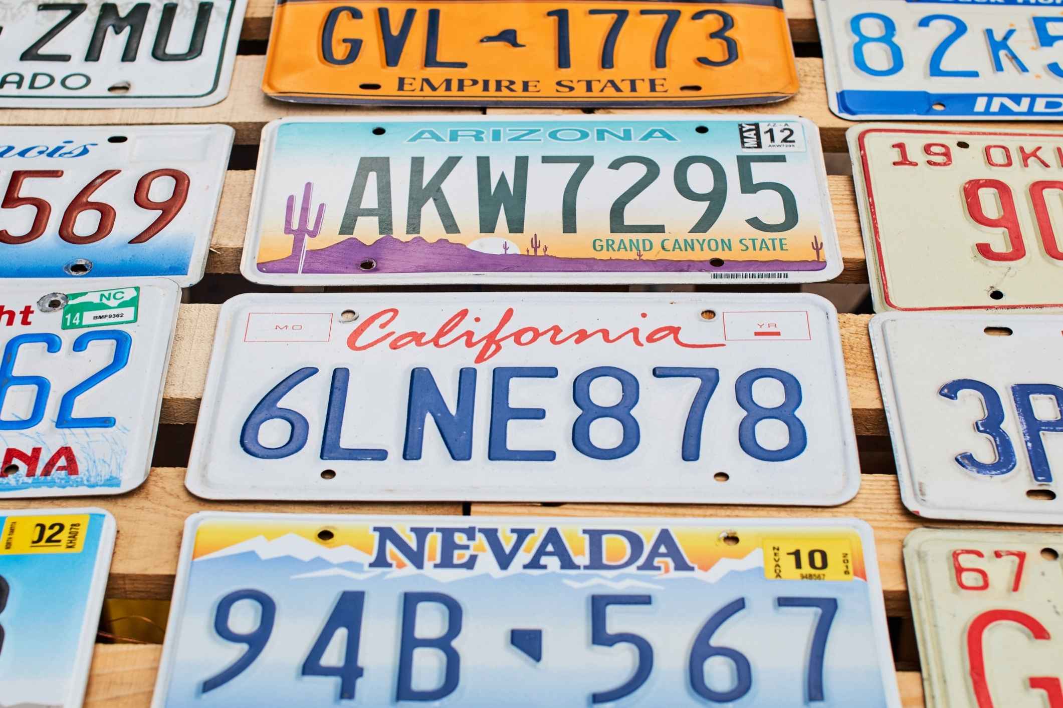 Vehicle license plates mounted on a wall, representing a license plate reader lawsuit.