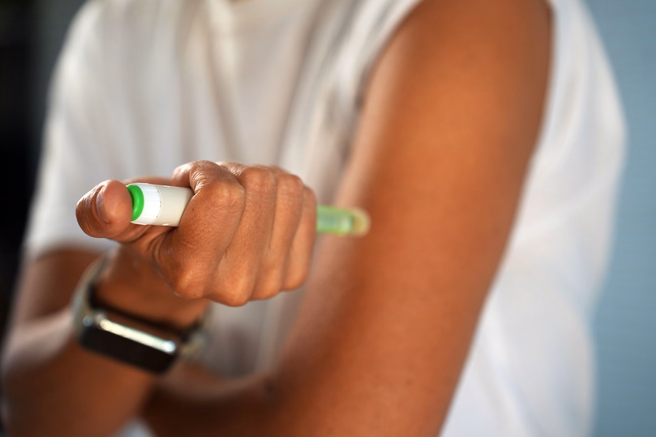 Close-up of a woman injecting medication with a pen, representing a Dupixent lawsuit claim.