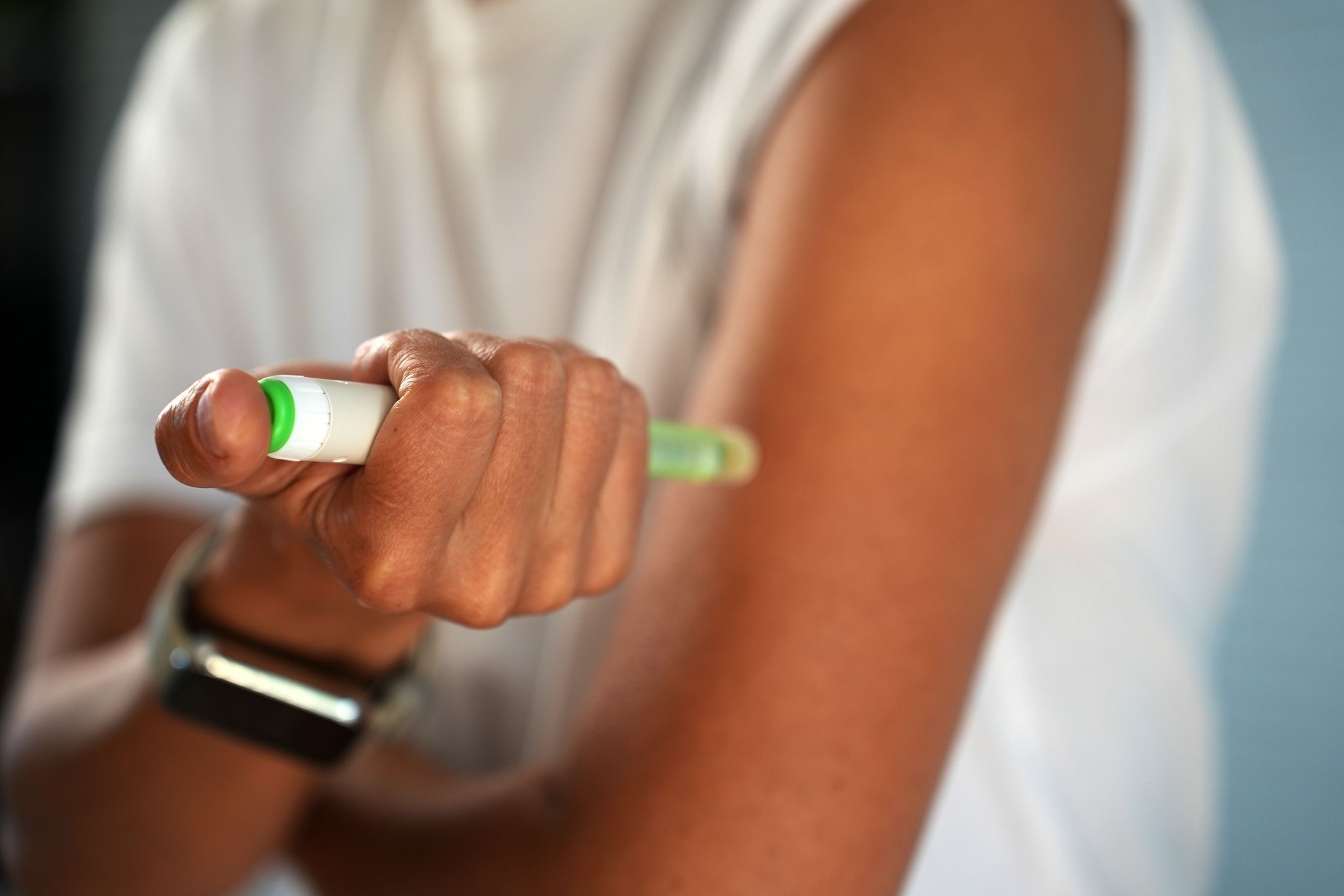 Close-up of a woman injecting medication with a pen, representing a Dupixent lawsuit claim.