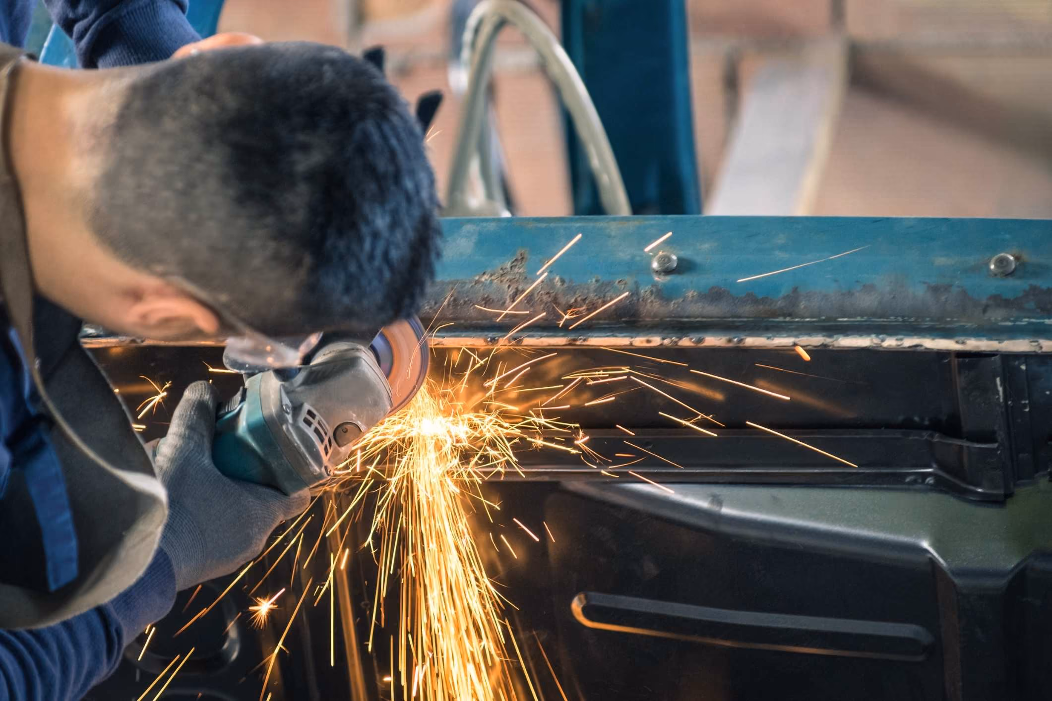 Auto worker grinding a car part tied to a General Motors asbestos trust claim.