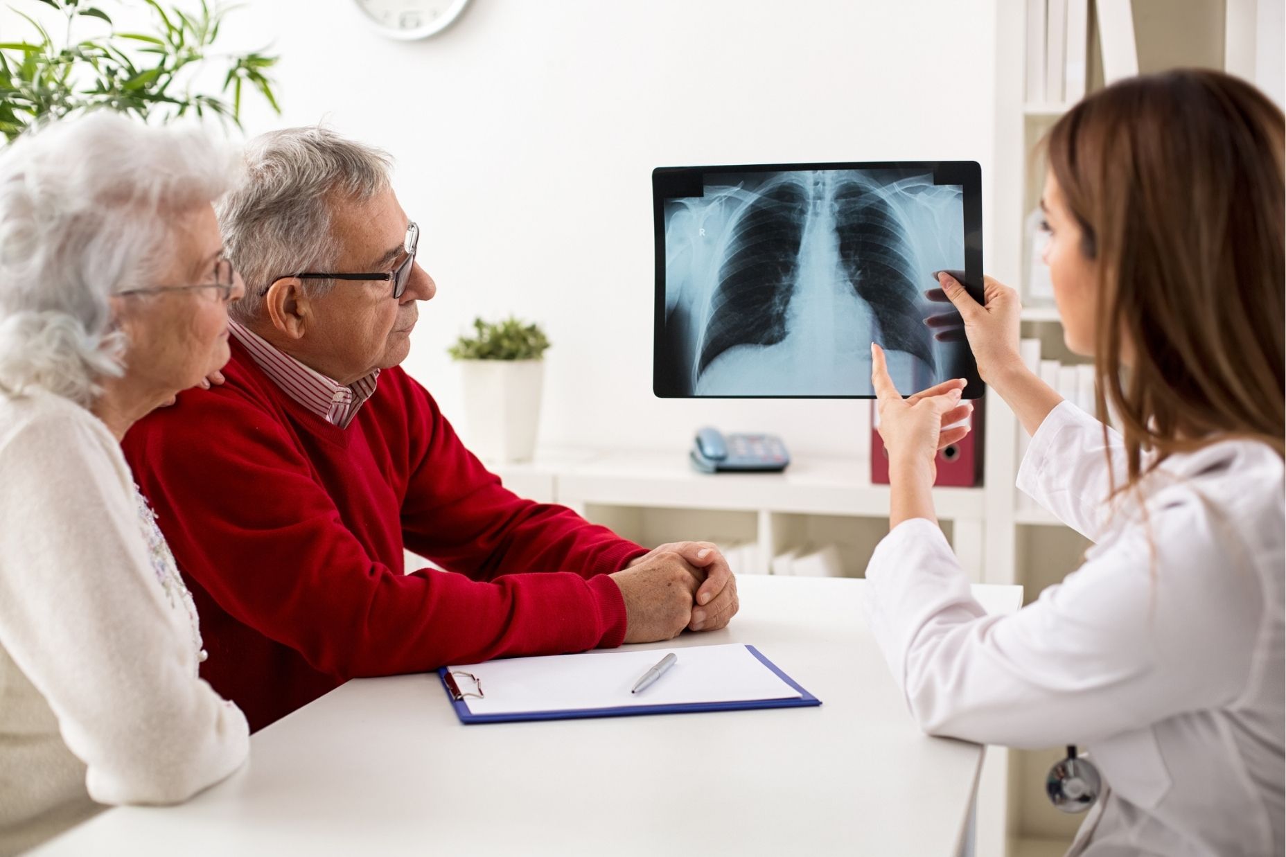 Doctor reviews a lung X-ray with a couple affected by Owens Corning asbestos exposure.