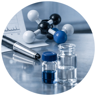 Molecular model, two small glass vials with liquids, and a pen on a reflective surface with a blurred chart in the background.