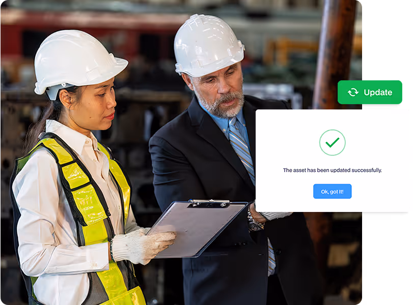 Facility inspectors in safety gear reviewing a maintenance checklist with a digital confirmation that an asset has been updated successfully.