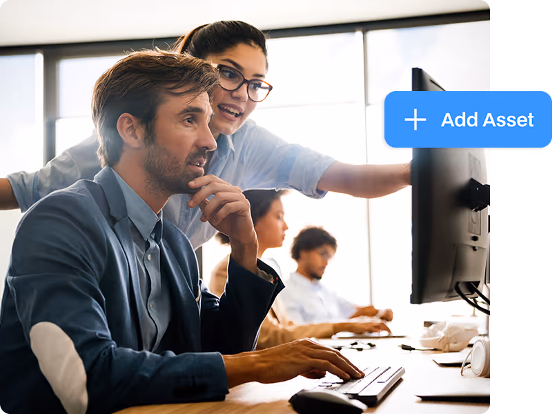 A facility management team in an office setting using a computer to add new assets and inventory items to their tracking system.
