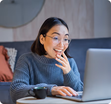 An excited facility manager discovering top-tier maintenance candidates using FM Dashboard’s hiring process guide on a laptop.