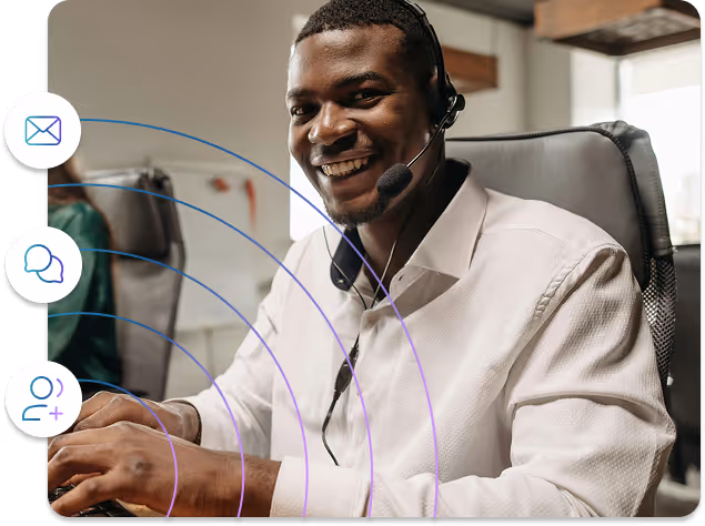 Smiling customer service representative wearing a headset and typing on a keyboard in an office.